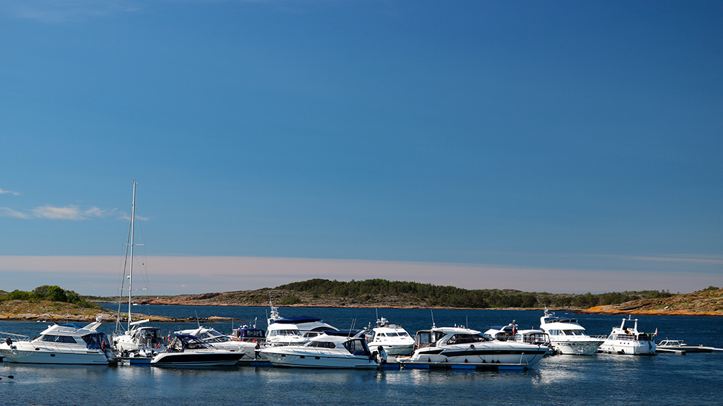 Mange båter som ligger i gjestehavnen på Østre Bolæren. Blå himmel. Foto.